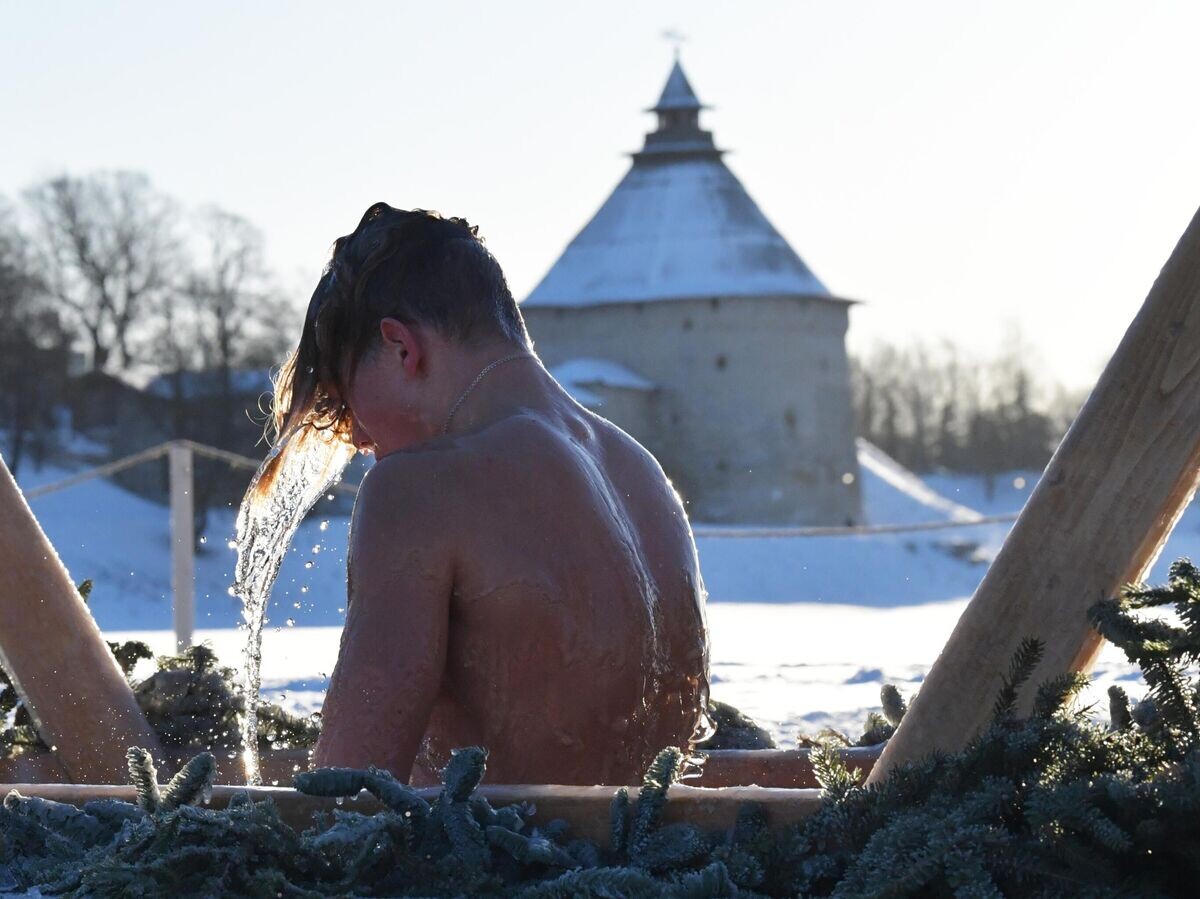   Молодой человек во время крещенских купаний на реке Великой у Мирожского монастыря в Пскове | © РИА Новости / Александр Гальперин