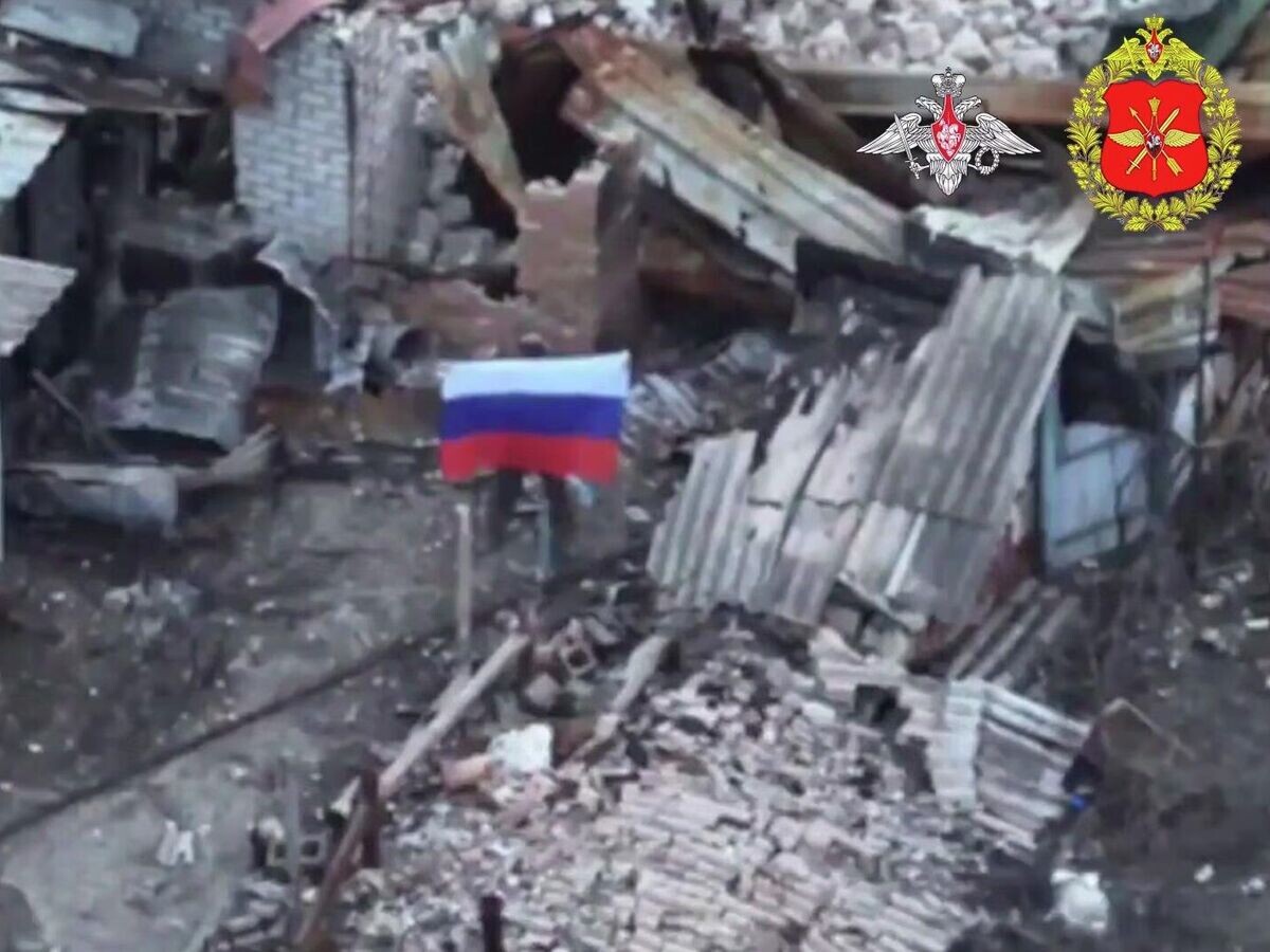    Военнослужащий с флагом РФ в населенном пункте Закотное, ДНР | © Минобороны России