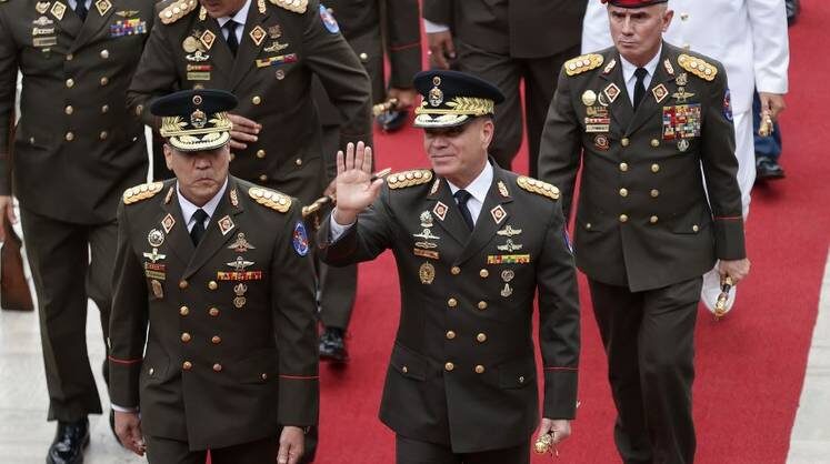    ТАСС/EPA Автор: RONALD PENA Министр обороны Венесуэлы Владимир Падрино Лопес (в центре) с группой генералов 15 января перед ежегодным посланием и. о. президента Венесуэлы Делси Родригес