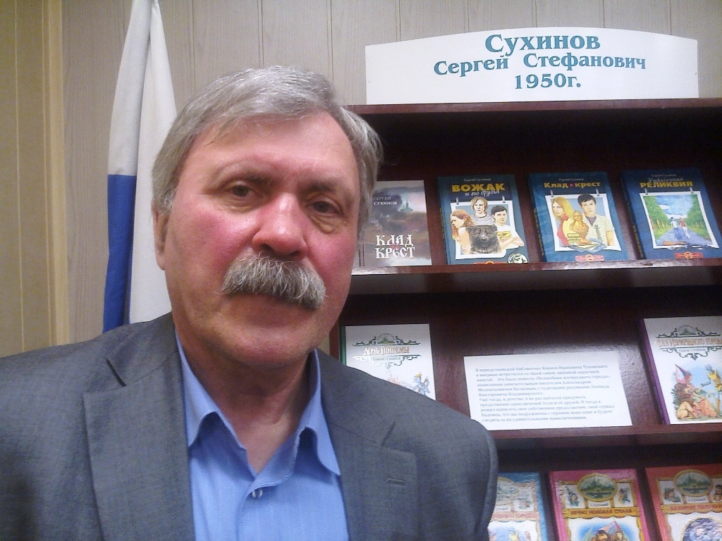 С.С. Сухинов у стенда со своими книгами. На верхней полке ранние издания трилогии "Клад и крест"