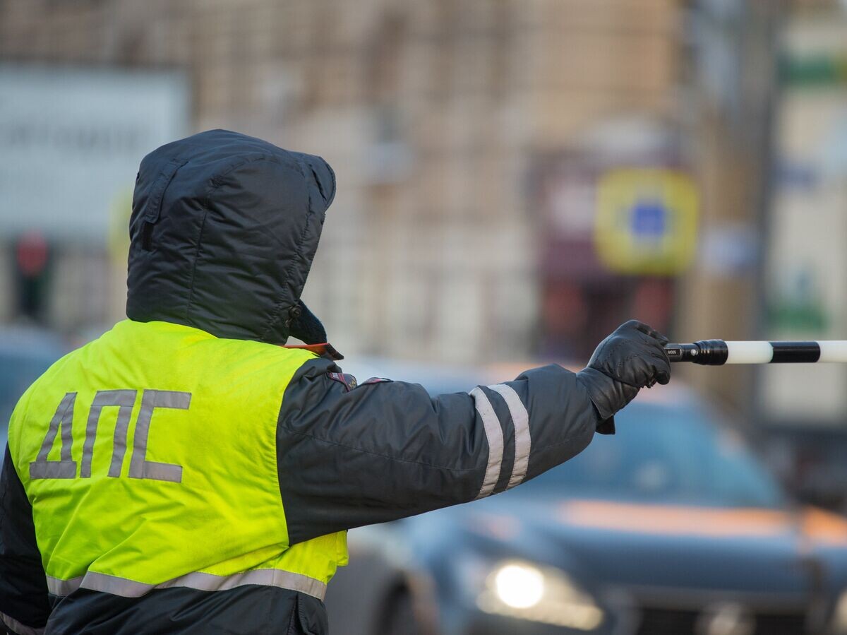    Сотрудник дорожно-патрульной службы дежурит на одной из улиц Москвы | © РИА Новости / Сергей Гунеев
