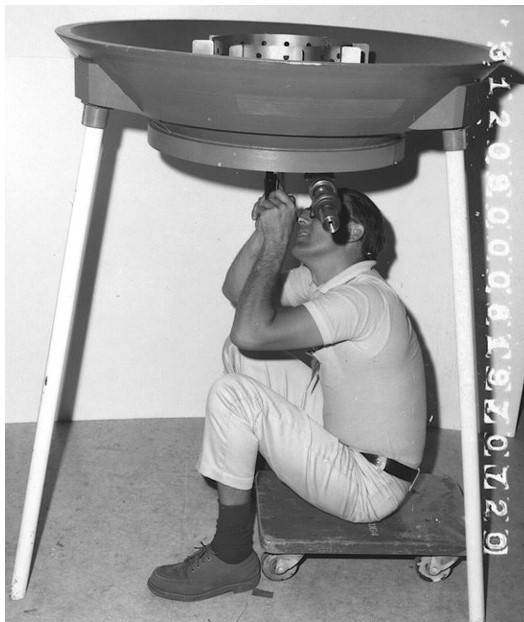 Техник компании Grumman тренируется устанавливать дефлектор на макете бака посадочной ступени лунного модуля.