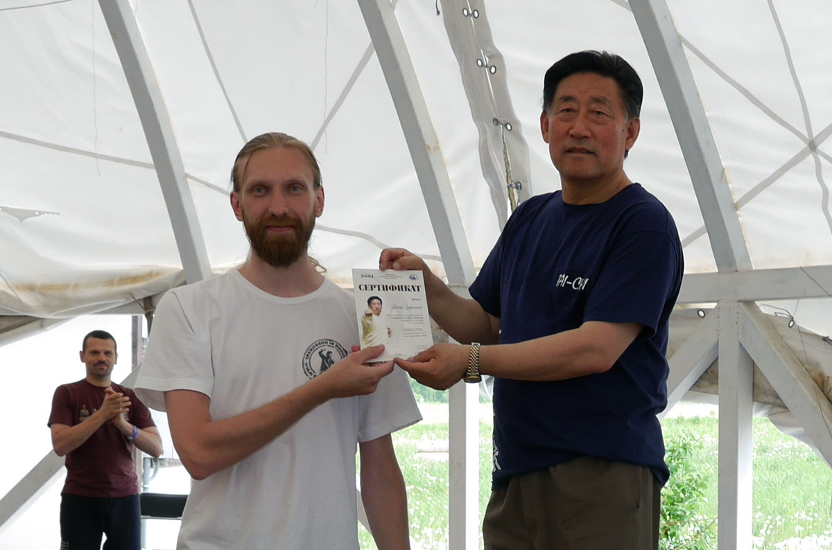 Чэнь Сяован вручает сертификат Евгению Завражнову