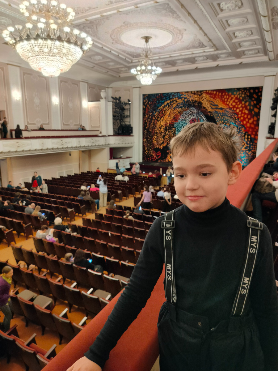 Сын на балконе с видом на зал театра