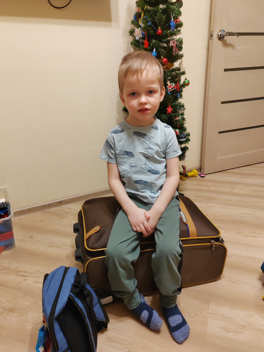 Паша на чемодане со своим рюкзачком