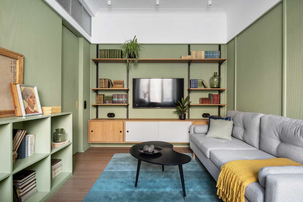 На фото: дизайн интерьера гостиной в зеленом цвете в квартире 22 кв.м в г. Москве. В кадре диван Динс от divan.ru. Дизайнер: Татьяна Пономаренко, студия PT buro; фотограф: Ольга Мелекесцева