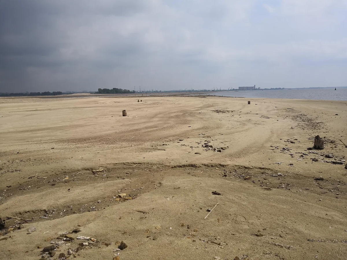 Вода отступившная на Волге в 2019 году в "обычном месте", где под водой был только песок или ил. Вдалеке виден остров Вороний Куст, казанский элеватор