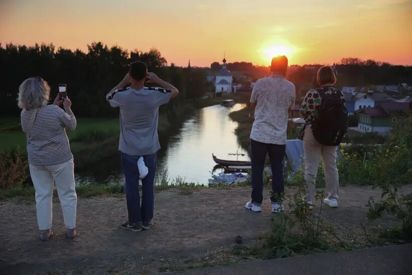     Туристы наблюдают закат на реке Каменка в Суздале. © РИА Новости. Виталий Белоусов
