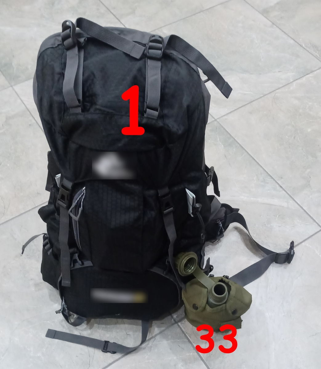 Тревожный комплект в сборе на фоне половой плитки и походной фляги.