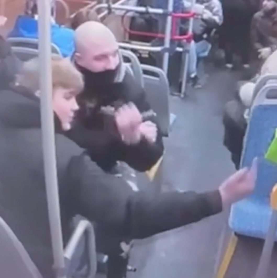 Кадры из салона автобуса с началом конфликта. Юноши показывают неприличные жесты. Иномали сидит чуть дальше, в кадр попал лишь рукав его бежевой куртки (справа сверху)