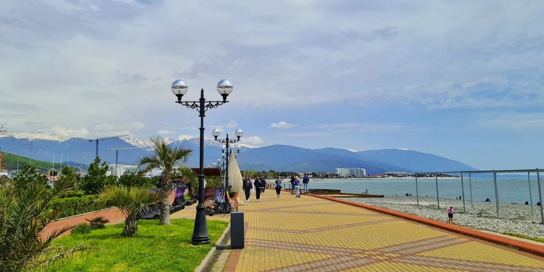 Адлер и набережная у Чёрного моря. Южный район Сочи с длинной прогулочной зоной вдоль воды.