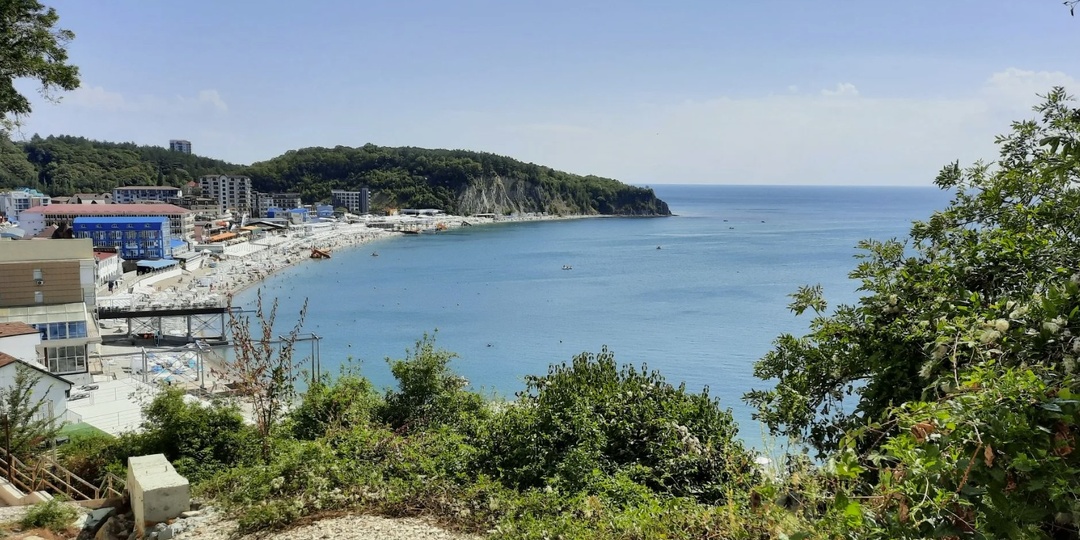 Ольгинка и морское побережье. Курортный посёлок Чёрного моря с горами и широкой береговой зоной.