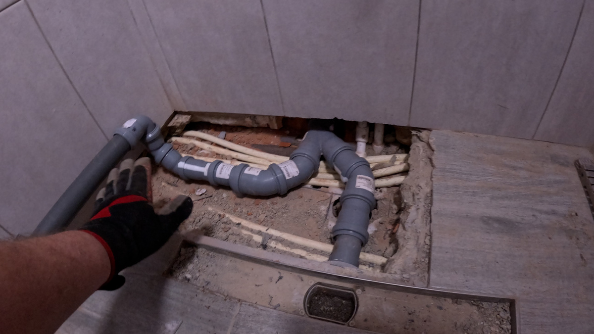 Проверлил отверстие и сантезники уже смонтировали новую трубу канализации в душевой