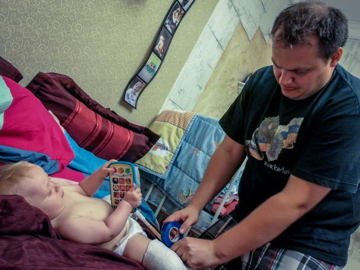 Папа обматывает распорку изолентой