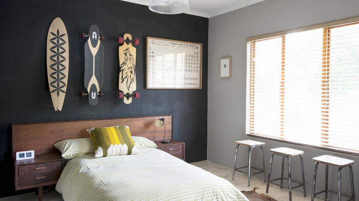 Используйте темные оттенки, такие как черный или антрацит, точечно, чтобы, как и здесь, подчеркнуть стену за кроватью в спальне.