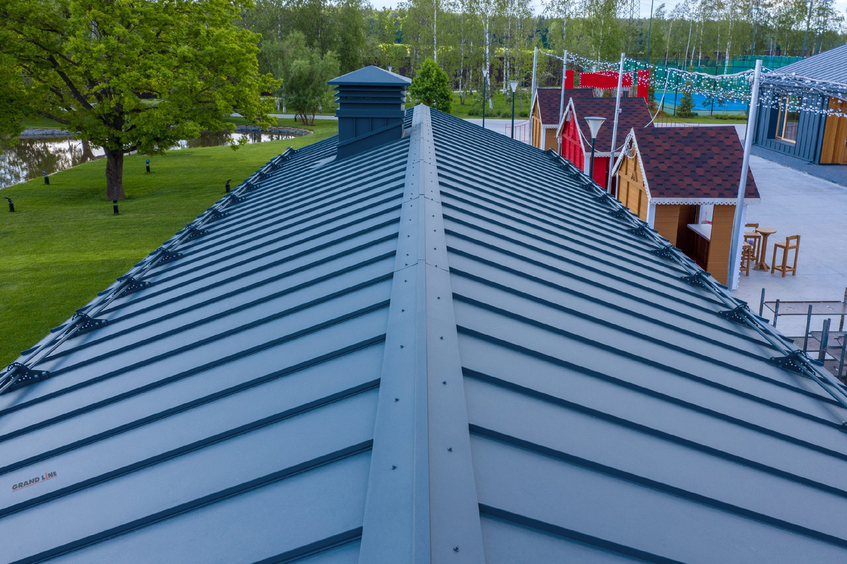 На фото: покраска металлической кровли