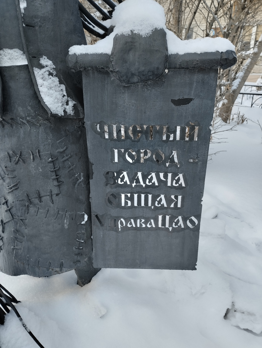 Табличка в руках дворника: "Чистый город - задача общая" 