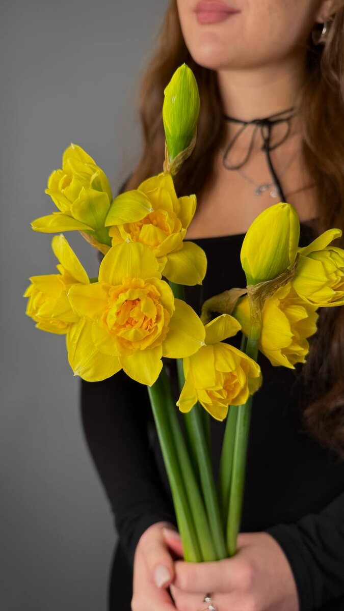 Ульяна — флористка Розмаркта, — держит в руках январские нарциссы, чтобы вскоре собрать с ними первый весенний букет в этом году