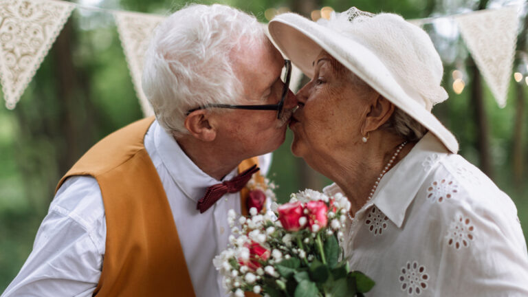    Senior couple having marriage and kising in nature during a summer day.
