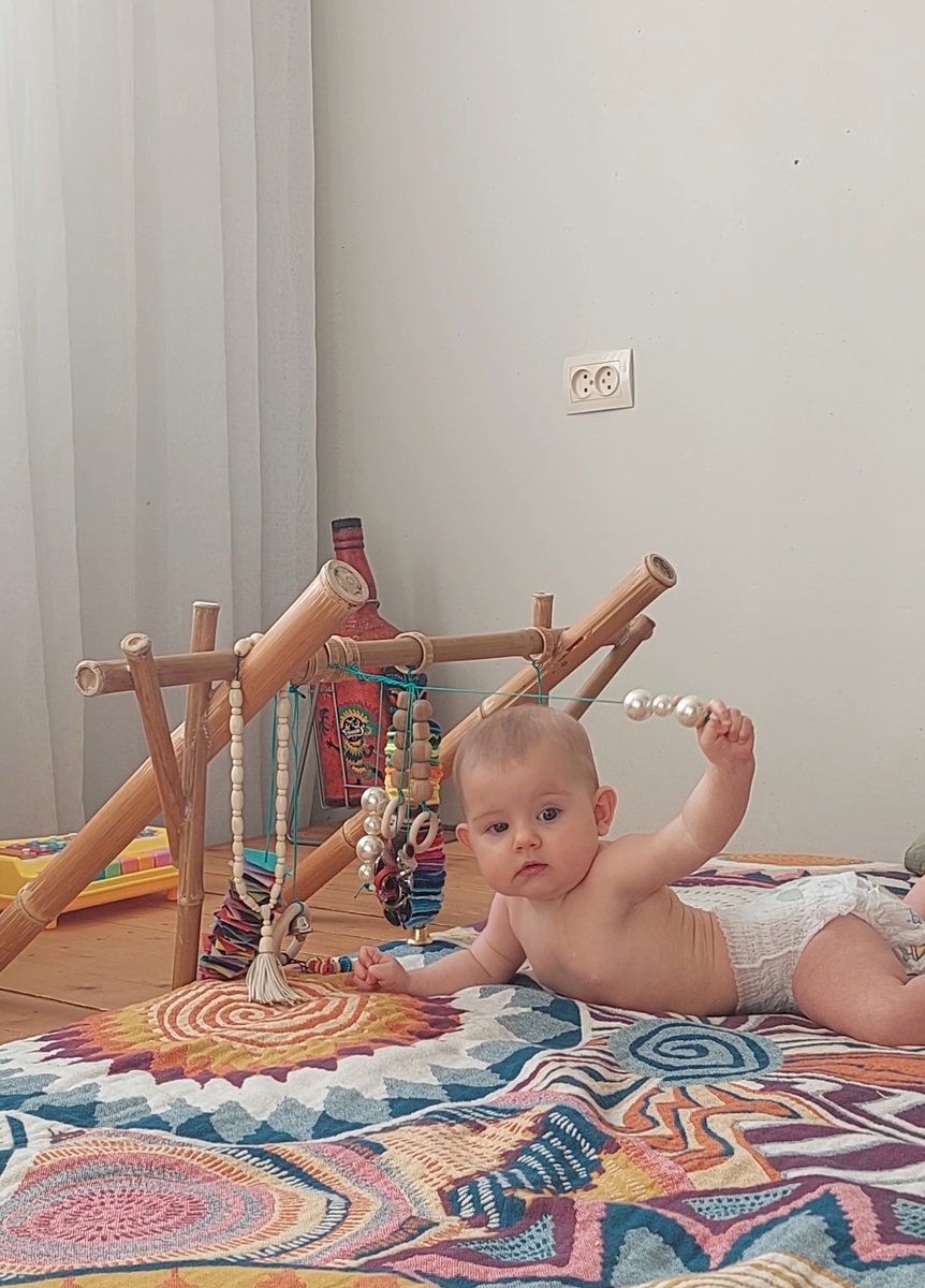 Инновация стойки с подвесами: опустила ножки между подиумом и матрасом, Катюха теперь колечки по штанге передвигает. И в рот подвесы удобнее тащить, и штучки на них всякие проще перебирать.