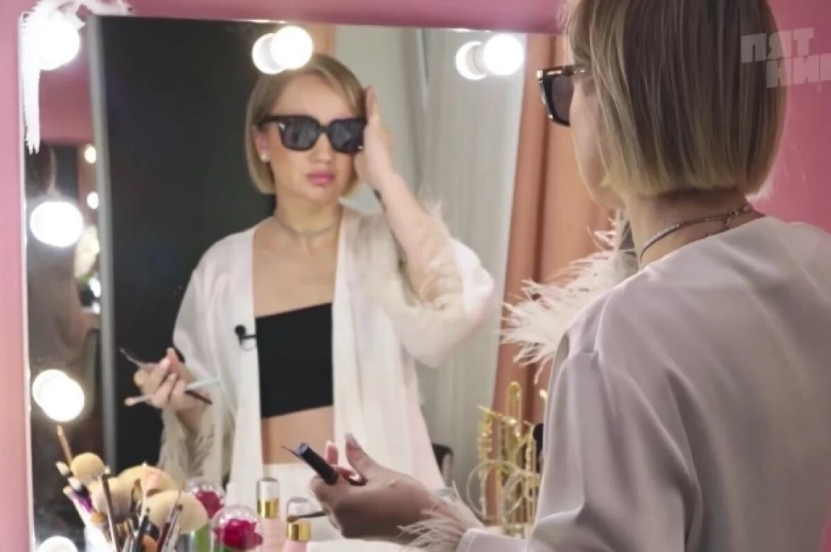    Женщина стесняется шрамов и прячет брови за массивными тёмными очками.