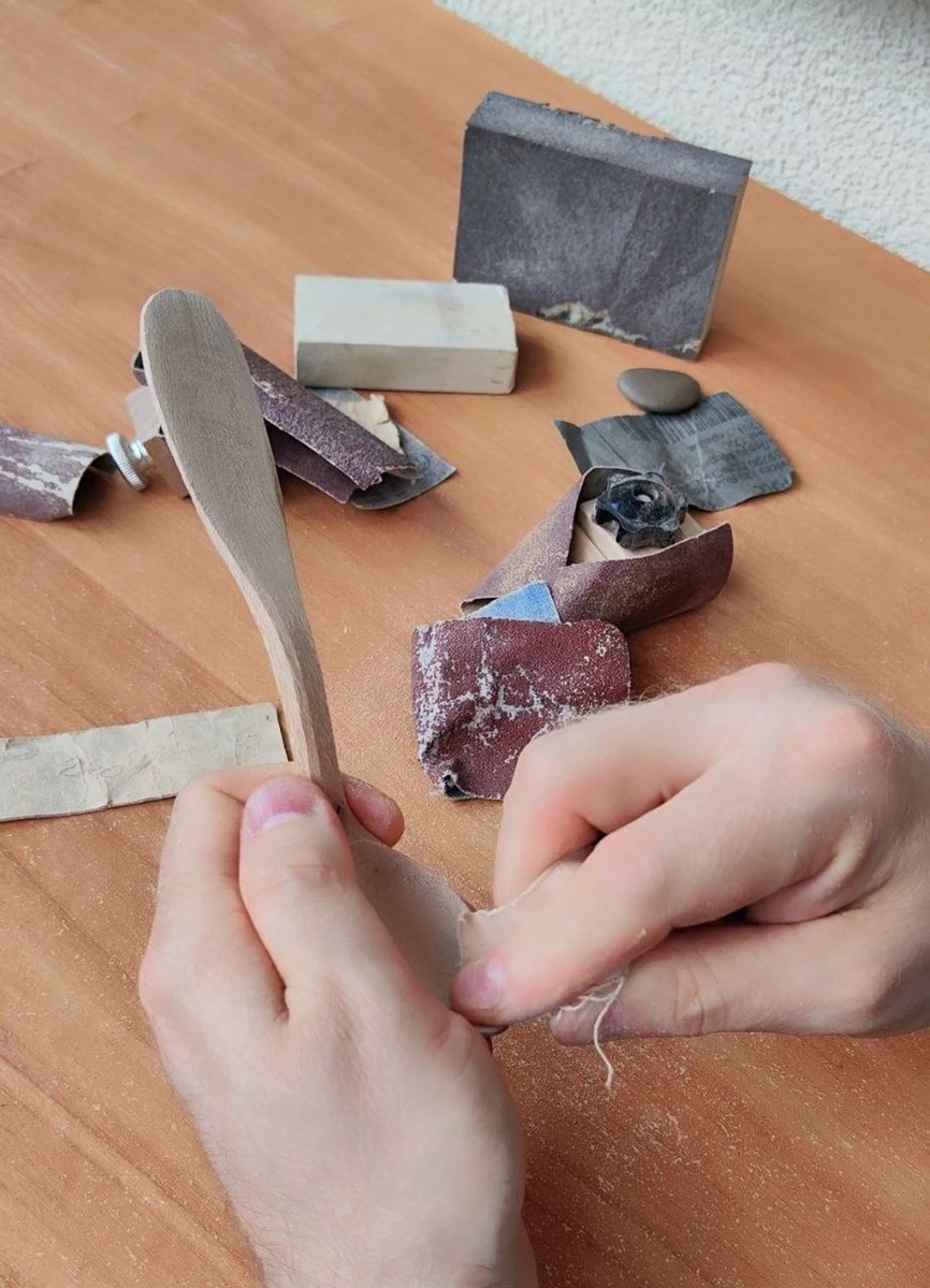 Шлифуем ложку, начиная от грубой шкурки до более мелкой и камушка