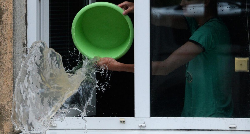    Юноша вычерпывает воду из своей квартиры | © РИА Новости / Виталий Аньков