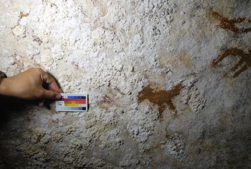 Слева и справа от нарисованной птицы, найденной в пещере Лианг Метандуно на острове Муна, на юго-востоке Индонезии, едва различимы отпечатки рук, самый древний из которых датируется примерно 67 800 лет назад.