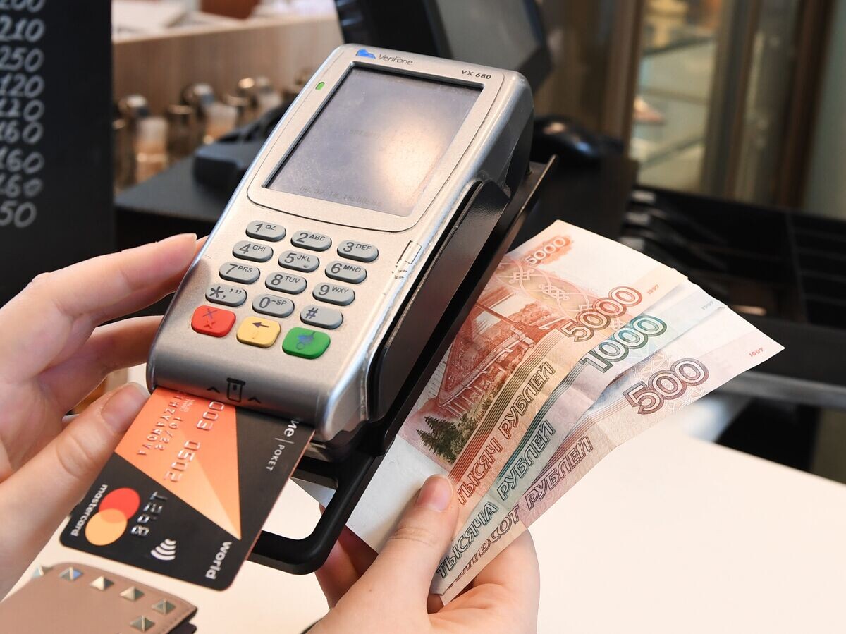    Терминал оплаты банковскими картами и денежные купюры.© РИА Новости . Екатерина Чеснокова