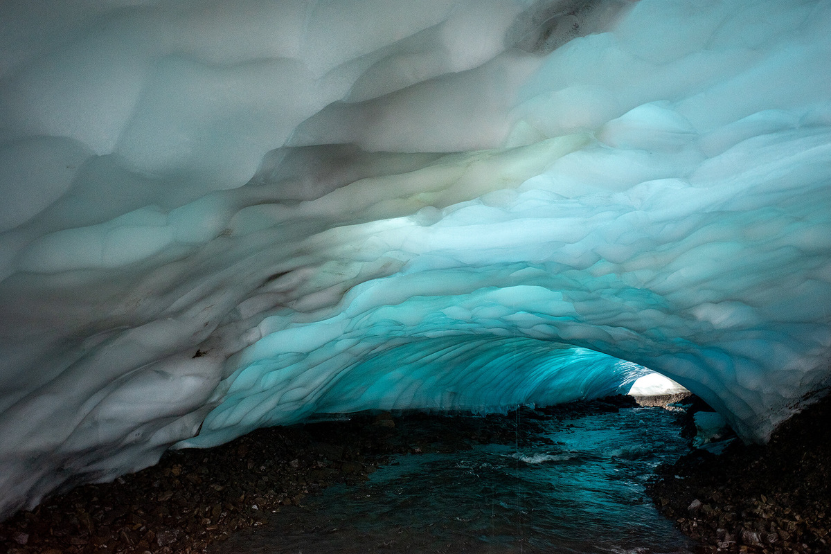 Эти пещеры создают потоки талой воды — они прокладывают себе путь внутри ледника, подтачивая его изнутри