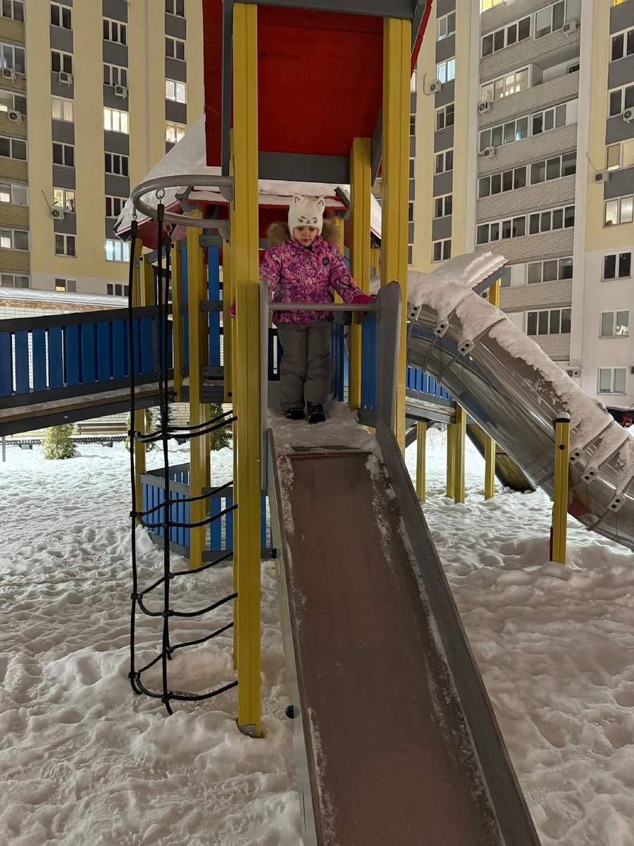 Катя осваивает горку во дворе нашего дома