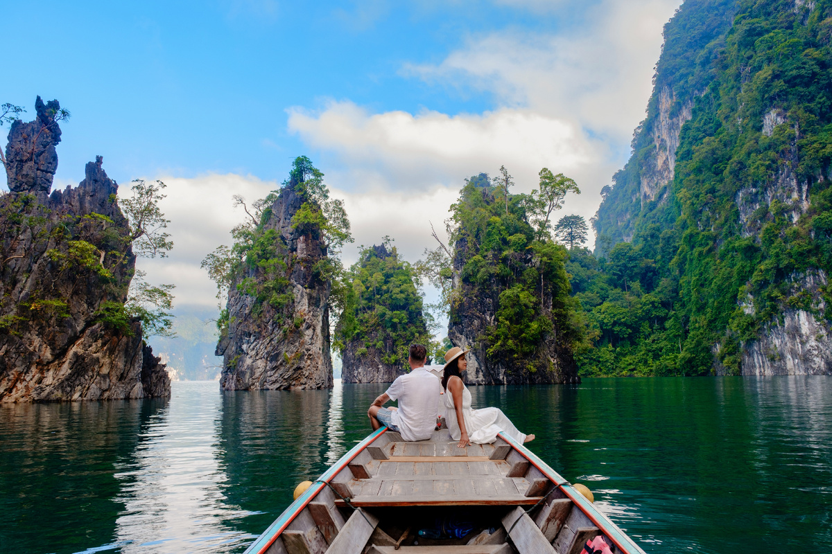 Пара отдыхает на традиционной лодке в спокойных водах озера Чжоу Лан в Као Соке, Таиланд. Источник: Shutterstock