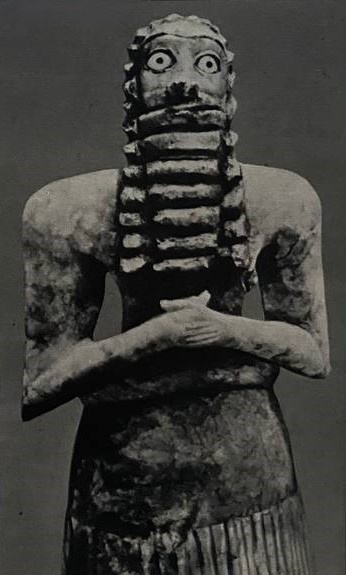 Мраморная статуя бородатого бога в бахромчатой юбке, относящаяся к той же эпохе. Волнистые волосы и борода почернены битумом