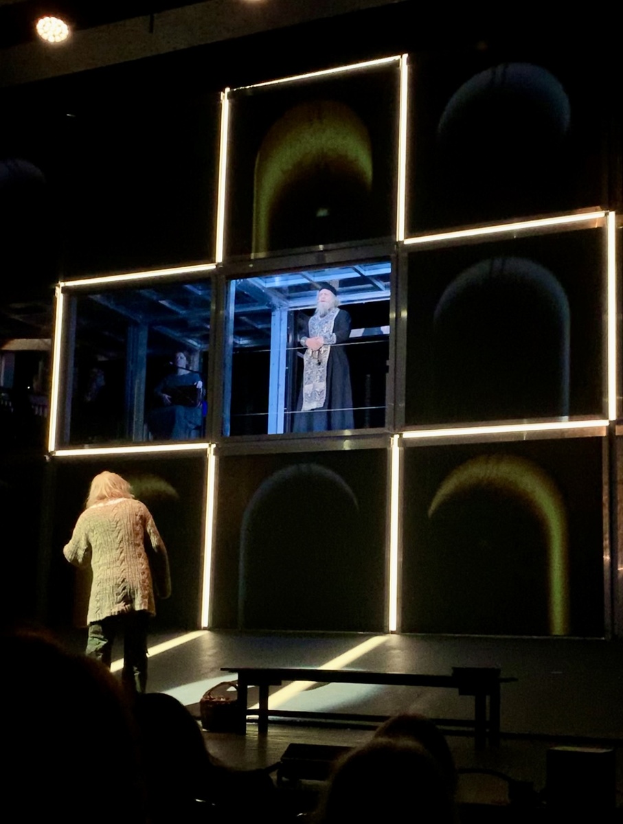 Сцена из спектакля. Очень интересная сценография, состоящая из боксов - квадратов, в которых периодически появляются актеры. 