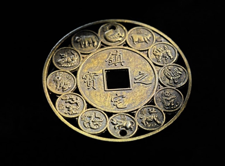 Старинная китайская медная монета с изображением двенадцати знаков зодиака.
