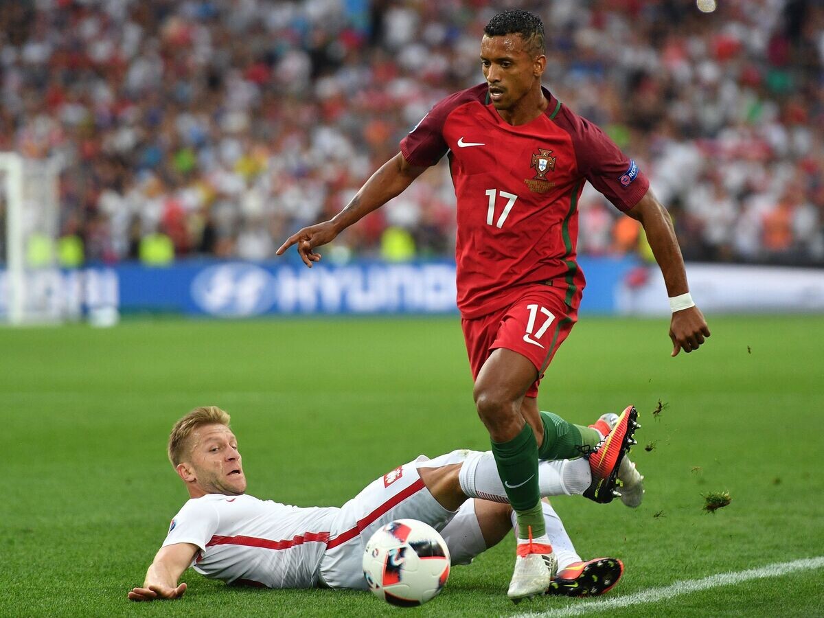    Полузащитник сборной Польши Якуб Блащиковский (слева) и полузащитник сборной Португалии Нани | © РИА Новости / Владимир Песня