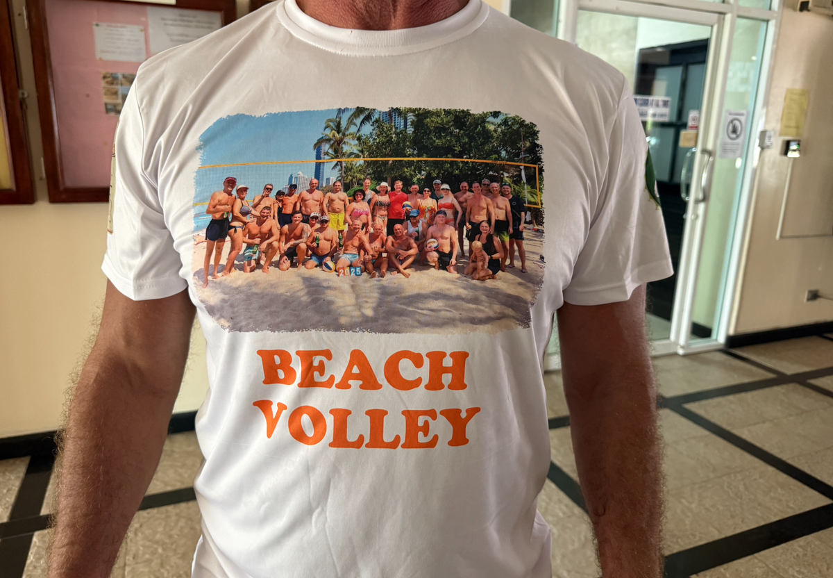 Дима демонстрирует футболку с участниками пляжного клуба