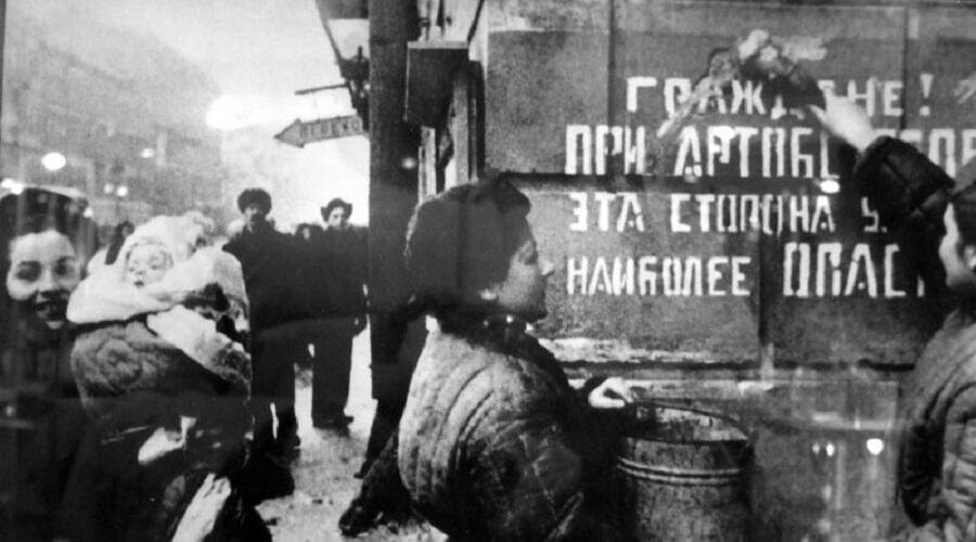    Ленинградцы закрашивают надпись на доме, предупреждающую об артобстрелах Фото: Давид Трахтенберг, добросовестное использование