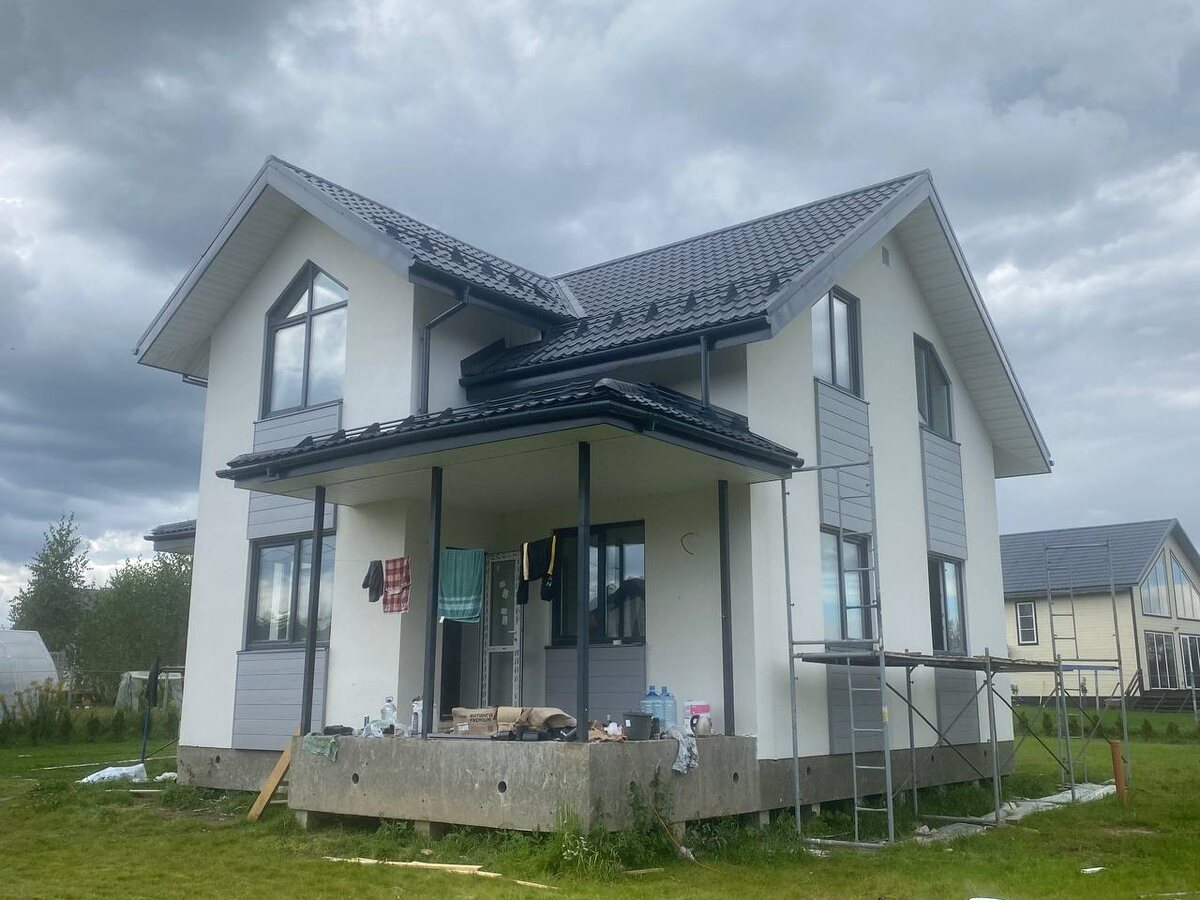 Объект Интел Групп. Дом из газобетона (площадь 129 м2) со сложной формой и выступающей частью под кровлей.