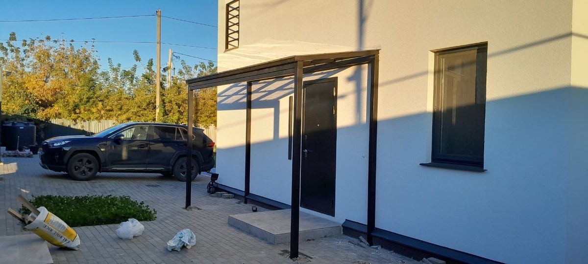 Вид навеса для входной двери и перила на балконе второго этажа