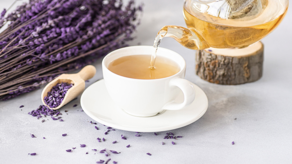 Лавандовый чай в прозрачном чайнике с сушеными бутонами лаванды и медом.