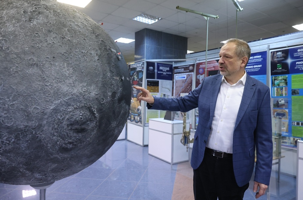    Этот огромный глобус Луны стоит в выставочном зале ИКИ РАН. Академик Петрукович показывает места посадки лунных станций разных стран. / Сергей Куксин