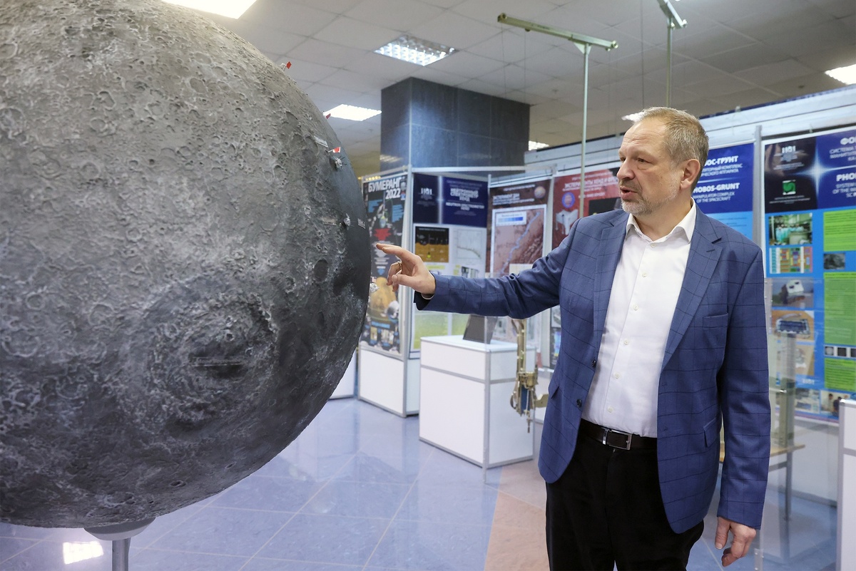    Этот огромный глобус Луны стоит в выставочном зале ИКИ РАН. Академик Петрукович показывает места посадки лунных станций разных стран./Сергей Куксин/ РГ