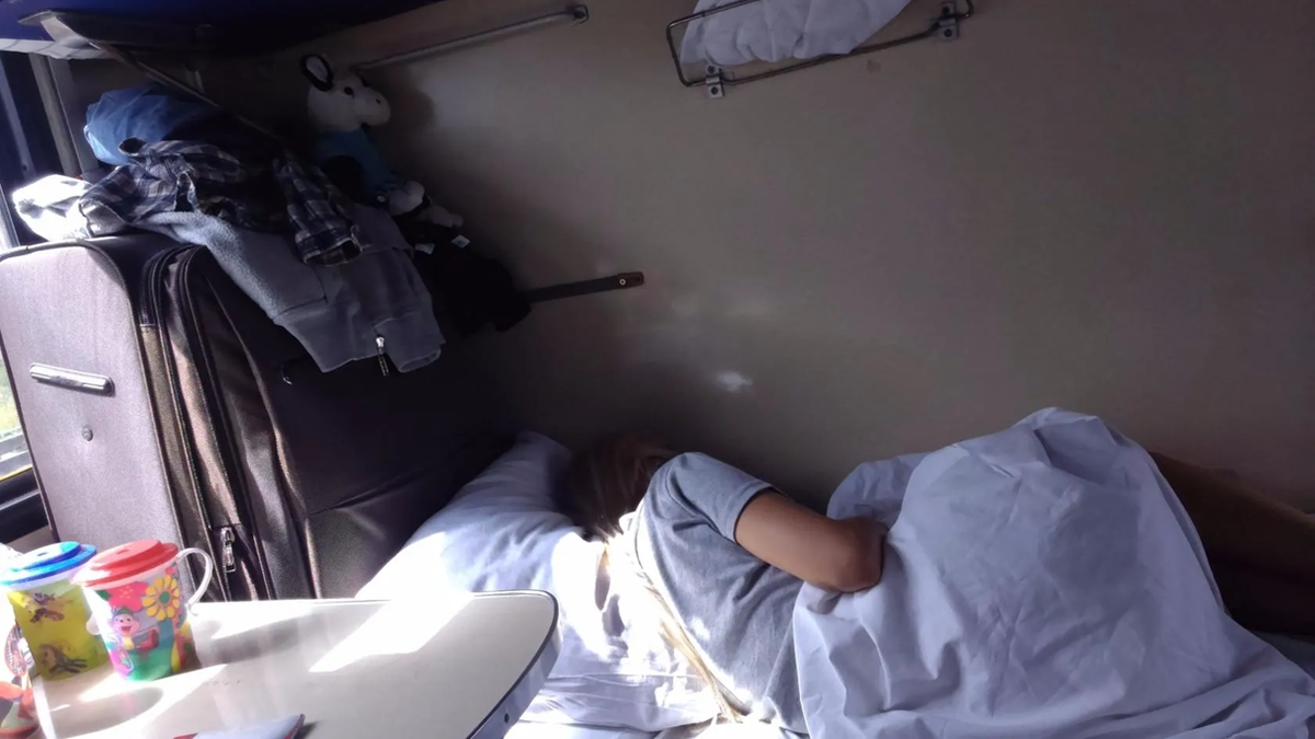 Дочкин чемодан такой большой, что не помещается в отделении под нижней полкой и поэтому гордо делит спальное место со своей хозяйкой.