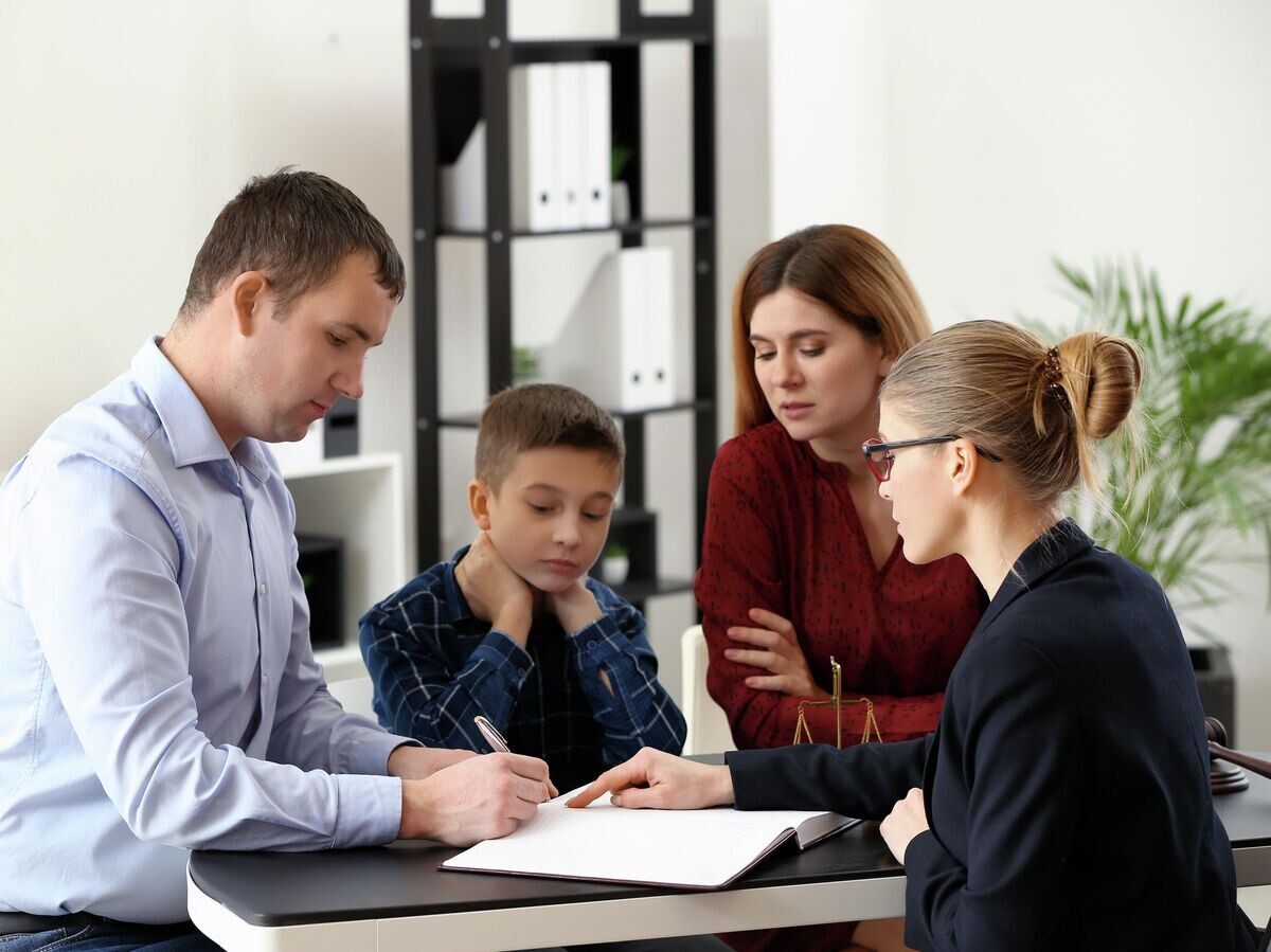    Разведенные родители с сыном у адвоката | © Depositphotos.com / serezniy