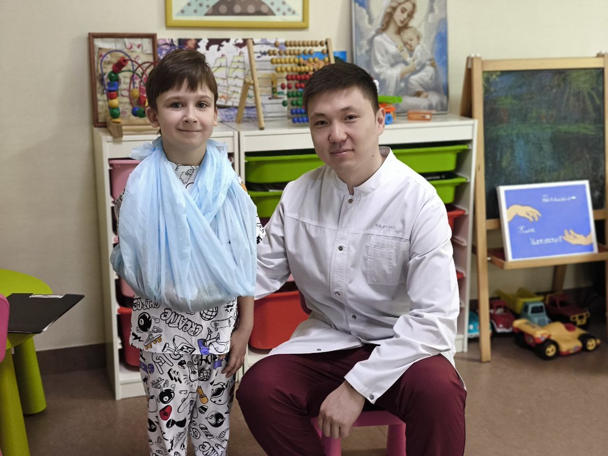 Шестилетний Демид хорошо себя чувствует после операции по удалению опухоли. На фото — с врачом-травматологом-ортопедом Дастанбеком Абдикапаровым