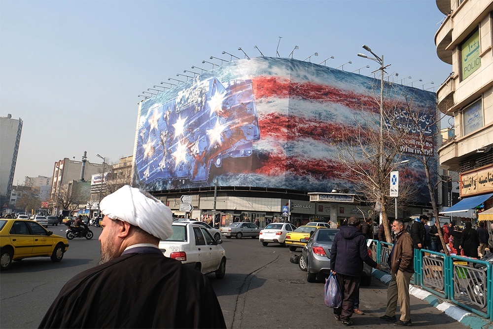    На центральной площади Тегерана - огромный щит с изображением горящего авианосца в цветах американского флага. На плакате слоган: "Если посеешь ветер, пожнешь бурю" - на персидском и английском языках. / Getty Images