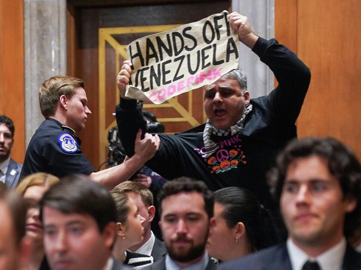    Мужчина с плакатом "Руки прочь от Венесуэлы" во время выступления госсекретаря США Марко Рубио на слушаниях Комитета Сената по международным отношениям | © REUTERS / Nathan Howard