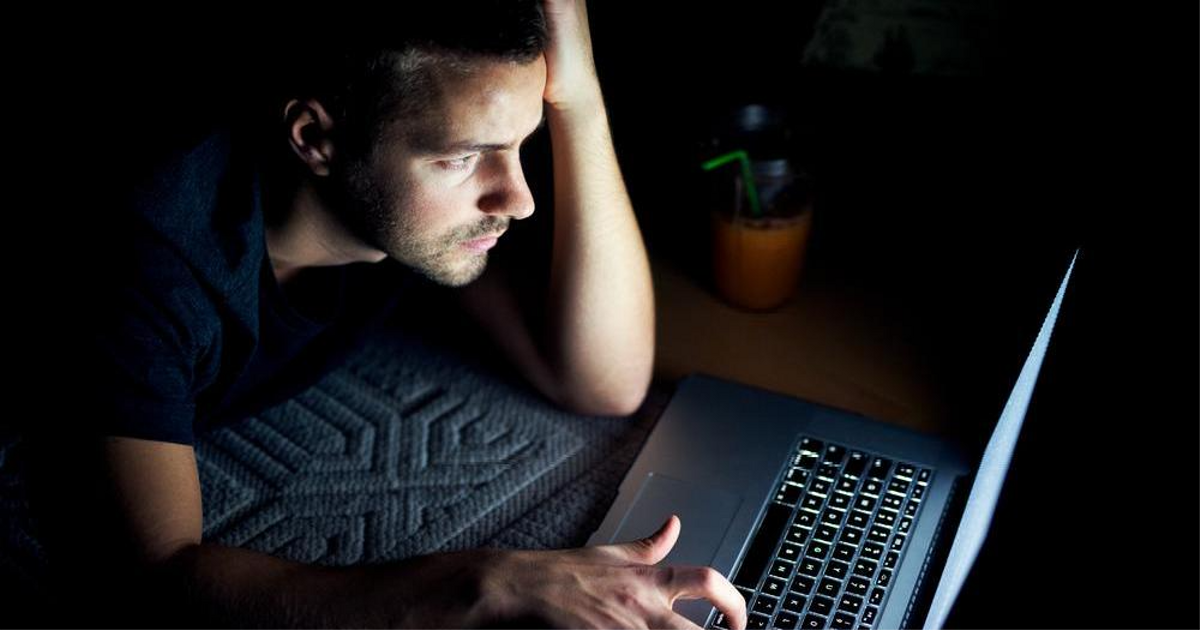 Новичок-фрилансер сидит за ноутбуком дома, на столе пусто, на лице сомнение — символ старта без опыта и заказов