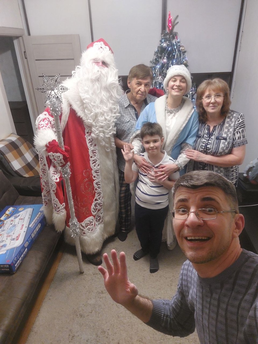        Снимок на память; слева на право : дед Мороз, я, внучочек Кямранбей, Снегурочка, Тимур и абям Ира; на диване лежит подарок игра в хоккей; дома в СПб, 27.12.2025.